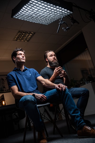 身着蓝色球衣的人坐在黑色水手领t恤的男子